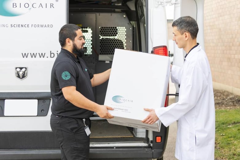 Driver and lab worker holding box