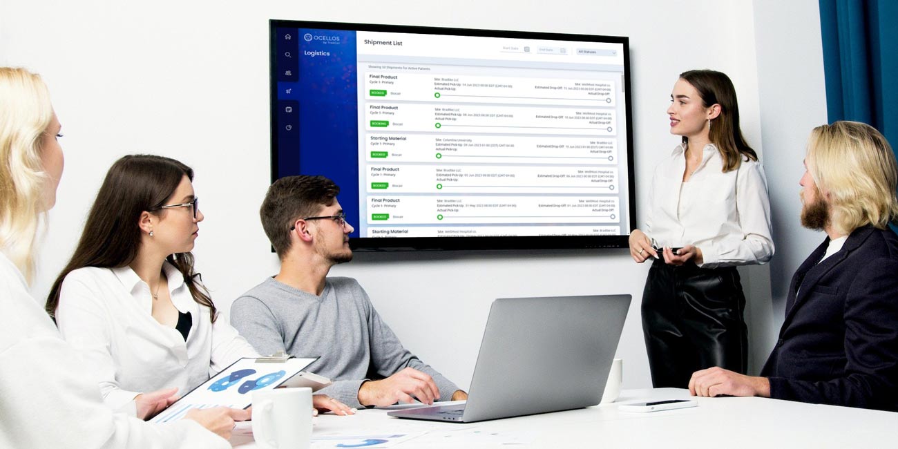 team evaluates logistics platform displayed on conference room monitor