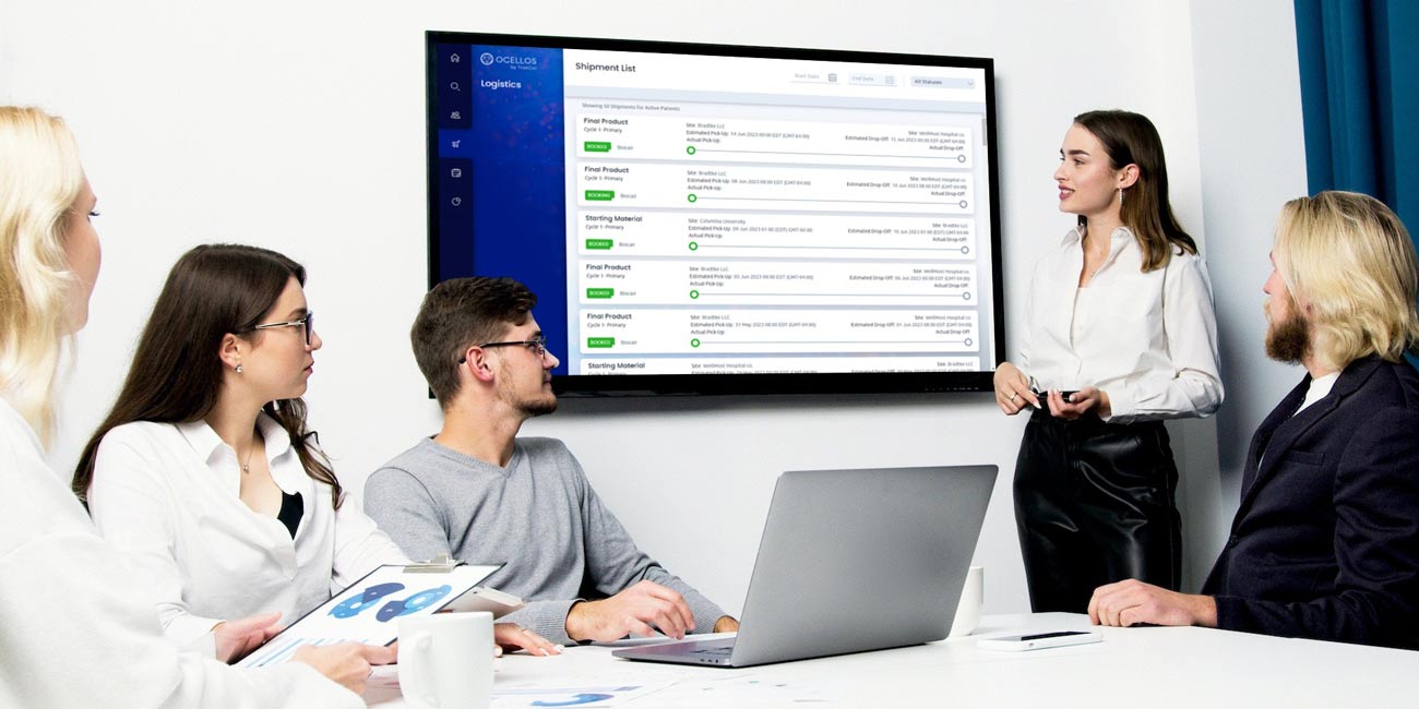 team looks at shipment tracking platform on conference room monitor