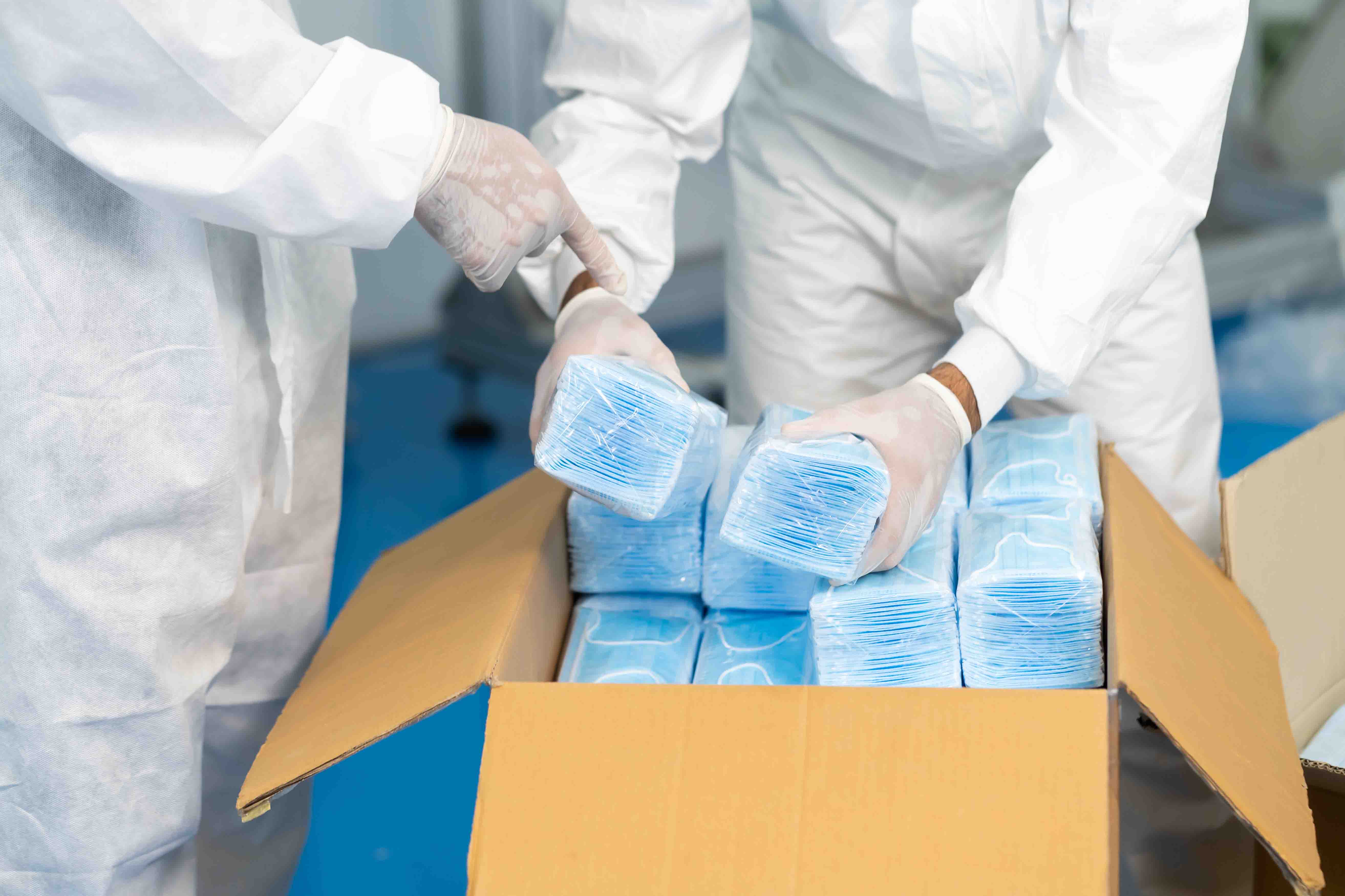 Workers are packing masks in boxes for delivery to customers.